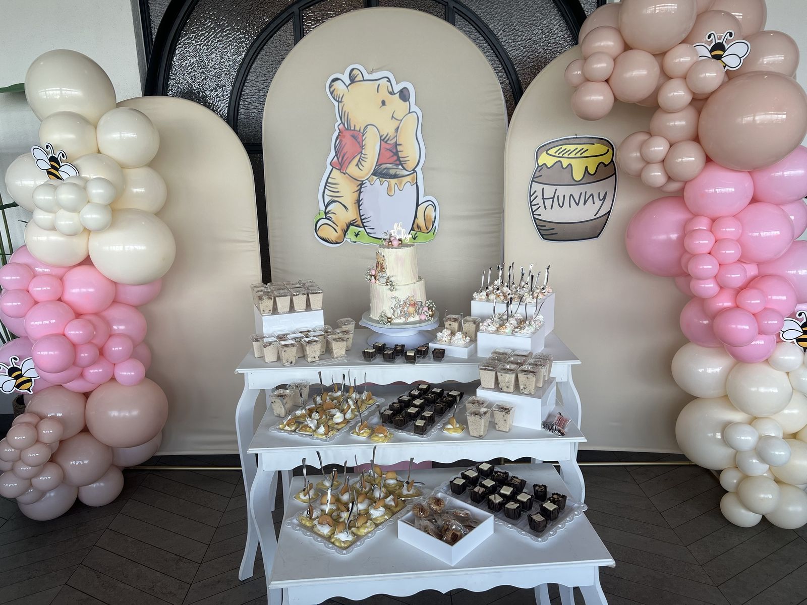 Baby shower dessert table with pink and cream balloon garland in El Paso