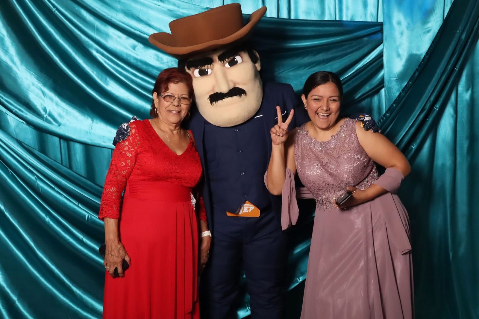 Guests in formal dresses with the UTEP mascot at the JVR photo booth