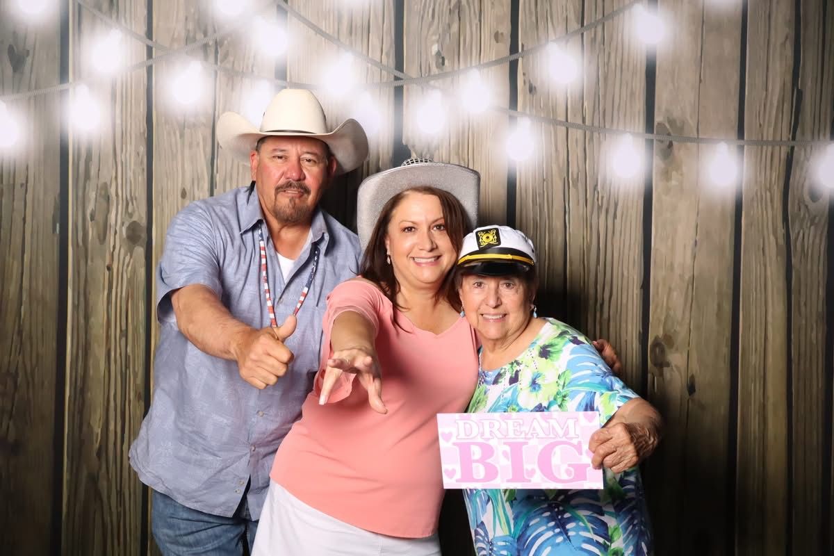 Family posing with a Dream Big sign at the JVR photo booth