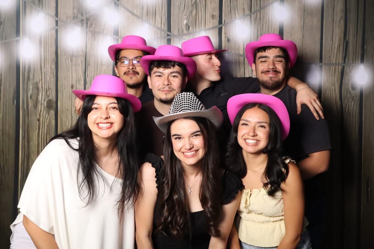 Group of friends in pink cowboy hats at the JVR photo booth