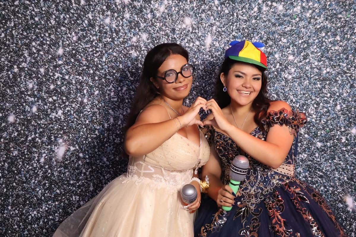 Quinceañera and friend making a heart at the JVR photo booth